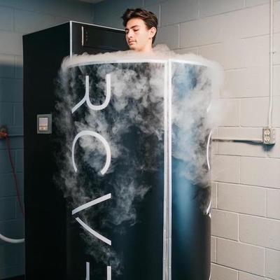 Man standing in cryogenic therapy chamber with smoke dispensing