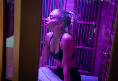 Woman sitting in infrared sauna relaxing