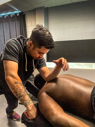 Male massage therapist using elbow to do deep tissue release on client